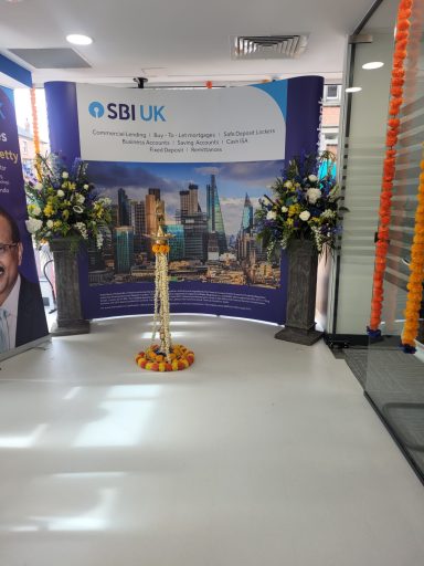 Decorative space with a lamp, flowers, and banners for an event at SBI UK.